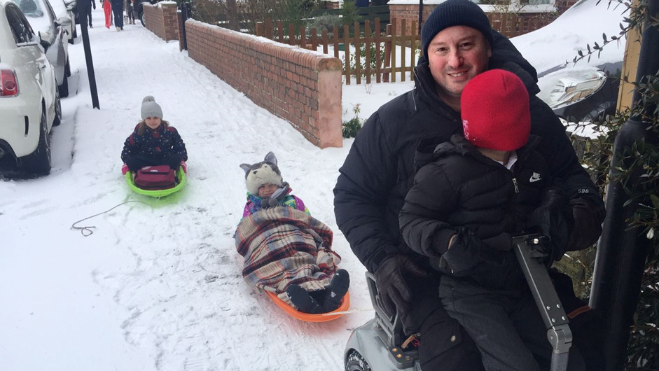 Layeth with his children playing in the snow with sledges